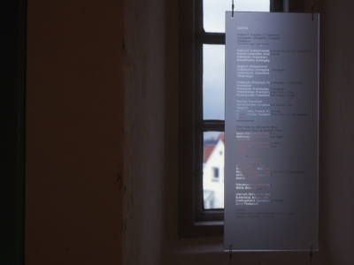 Blomsternavne sandblæst i glas, hængende foran et af de få, små vinduer. (billede 1 af 2)