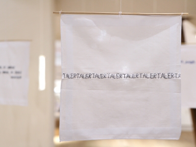 Enkelthængende, bevægelige, nye damelommetørklæder med håndbroderede tekster.